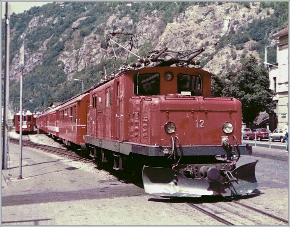Die BVZ HGe 4/4 12 ist mit dem Glacier Express von Zermatt kommend in Brig eingetroffen. (Bildberabeitung H.K) 31. Juli 1983