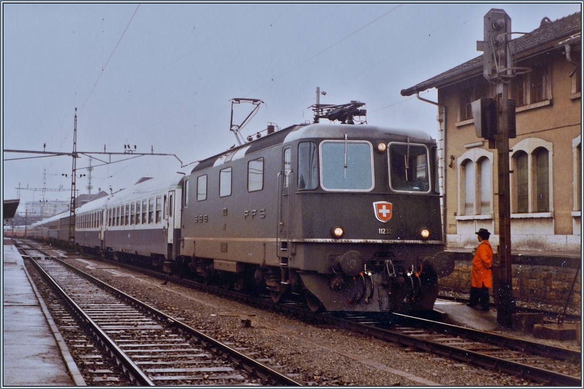 Die SBB Re 4/4 II 11232 wartet nach der Übernahme des  Hispania - Express nach dem Fahrtrichtungswechsel in Delémont auf die Weiterfahrt nach Basel. Der Zug besteht aus zwei Teilen: dem IC/EC Hispania von Genève nach Hamburg und dem Nachtzug Port-Bou bzw. Cerbère - Basel (-Hamburg).

16. Sept. 1984 
