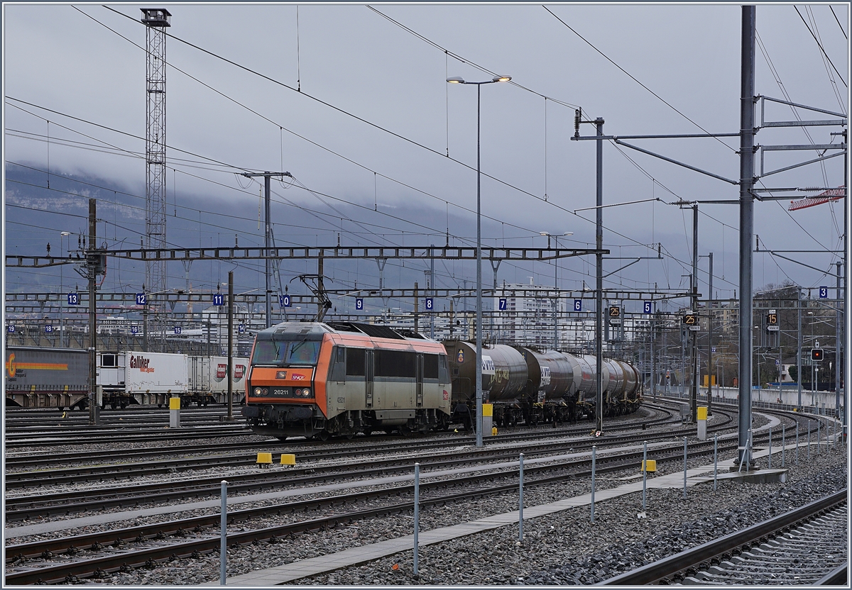 Ein Blick vom Lancy Pont Rouge in den Güterbahnhof Genève La Praille: Dort wartet die SNCF BB 26211 auf die Abfahrt Richtung Frankreich (via La Plaine). 

13. Februar 2020