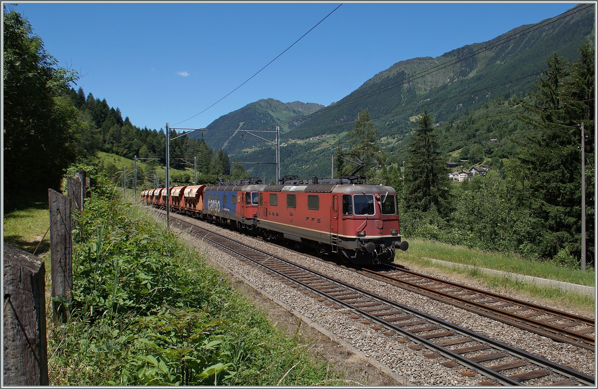 Eine  Re 10/10  mit der Re 4/4 II 11259 und einer Re 6/6 sind mit einem Kieszug bei Rodi Fieso auf dem Weg Richtung Süden. 

24. Juni 2015