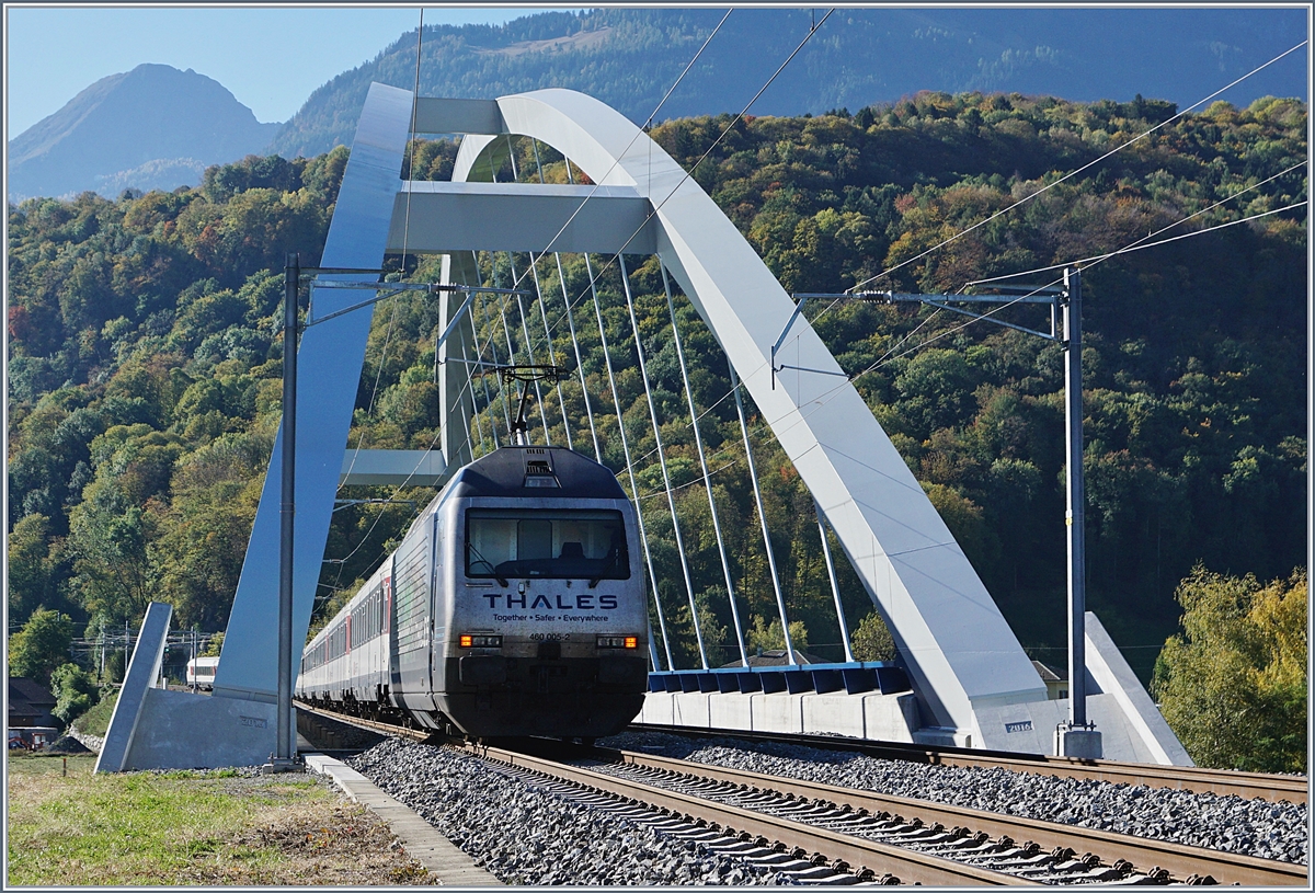 Fast 23 Meter über die Gleise wölbt sich die beiden Bögen der SBB Brücke  Massogex , die zwischen Bex und St-Maurice über die Rhone führt. Die Brücke weist eine Spannweite von 125.8 Meter auf und gilt als längste Stählerne Eisenbahnbrücke der Schweiz. Sie ersetzt seit 2016 die beiden aus den Jahren 1903 und 1924 stammenden eingeleisigen Stahlbrücken. (Tech. Ang. Quelle: TEC21 Nr 41). Das Bild zeigt die SBB Re 460  einen SBB 460 005-2 mit einem IR auf der Fahrt Richtung Brig.
11. Okt. 2017 