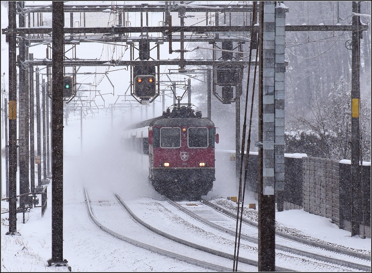 Heftiger Schneefall vor genau zwei Jahren in Tecknau. Re 4/4 II 11197 kämpft sich mit einem IR den Weg zum Hauen
steinbasistunnel frei. Januar 2017.
