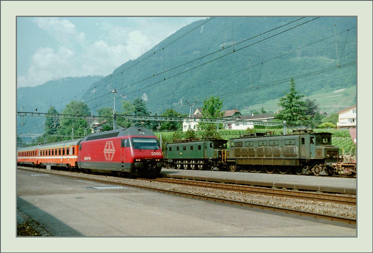 Während eine SBB Re 460 mit einem EC in Richtung Milano unterwegs ist und in Villeneuve durchfährt, waren zwei Ae 4/7 in Vielfachsteuerung mit einem Güterzug auf die Abfahrt

August 1995