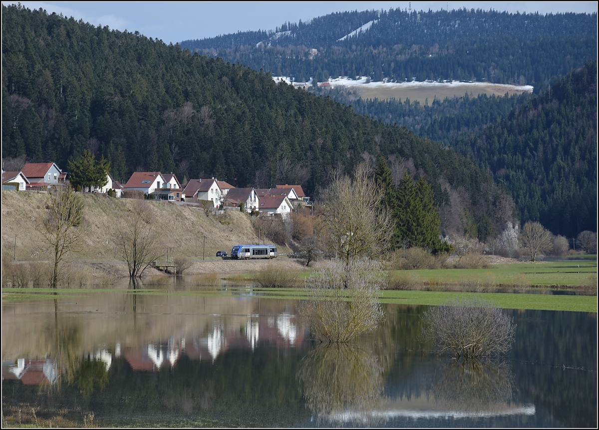 X 73755 bei der Einfahrt nach Morteau. Im Vordergrund der über die Ufer getretene Doubs. April 2018.