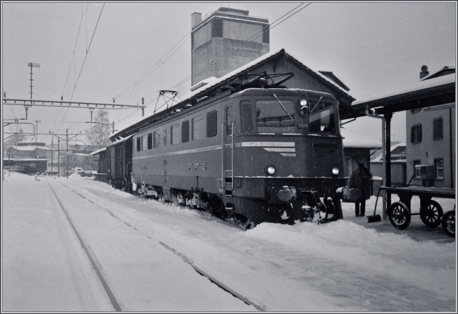 An einem trüben und schneereichen Märztag steht die SBB Ae 6/6 11416  Glarus  mit einem Postwagen in Beromünster auf Gleis 1.

Analogbild vom März 1988