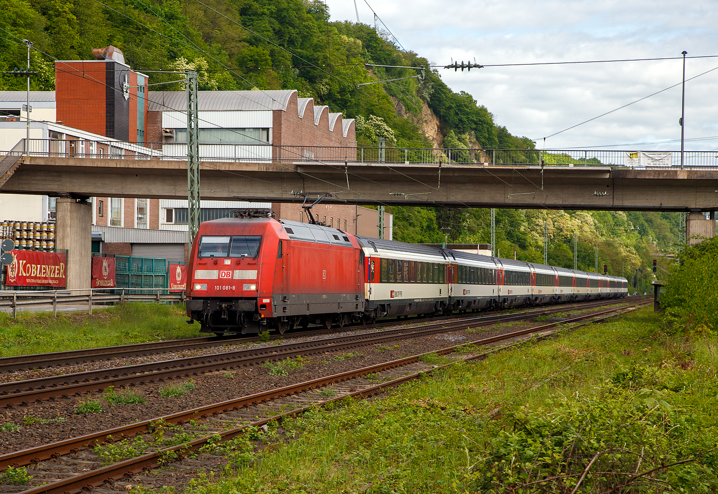 Die 101 081-8 (91 80 6101 081-8 D-DB) der DB Fernverkehr AG, fährt am 28.04.2018, mit einem EC bestehend aus SBB EuroCity-Wagen, auf der Linken Rheinstrecke (KBS 471) durch Koblenz-Oberwerth, in Richtung Mainz bzw. Schweiz.

Die EuroCity-Wagen (Apm EC und Bpm EC) der SBB sind zwar nach ähnlichen Prinzipien aufgebaut worden, werden aber in der Schweiz nicht als Einheitswagen bezeichnet. 

Die Lok wurde 1996 von ADtranz (ABB Daimler-Benz Transportation GmbH) in Kassel unter der Fabriknummer 33191 gebaut.
