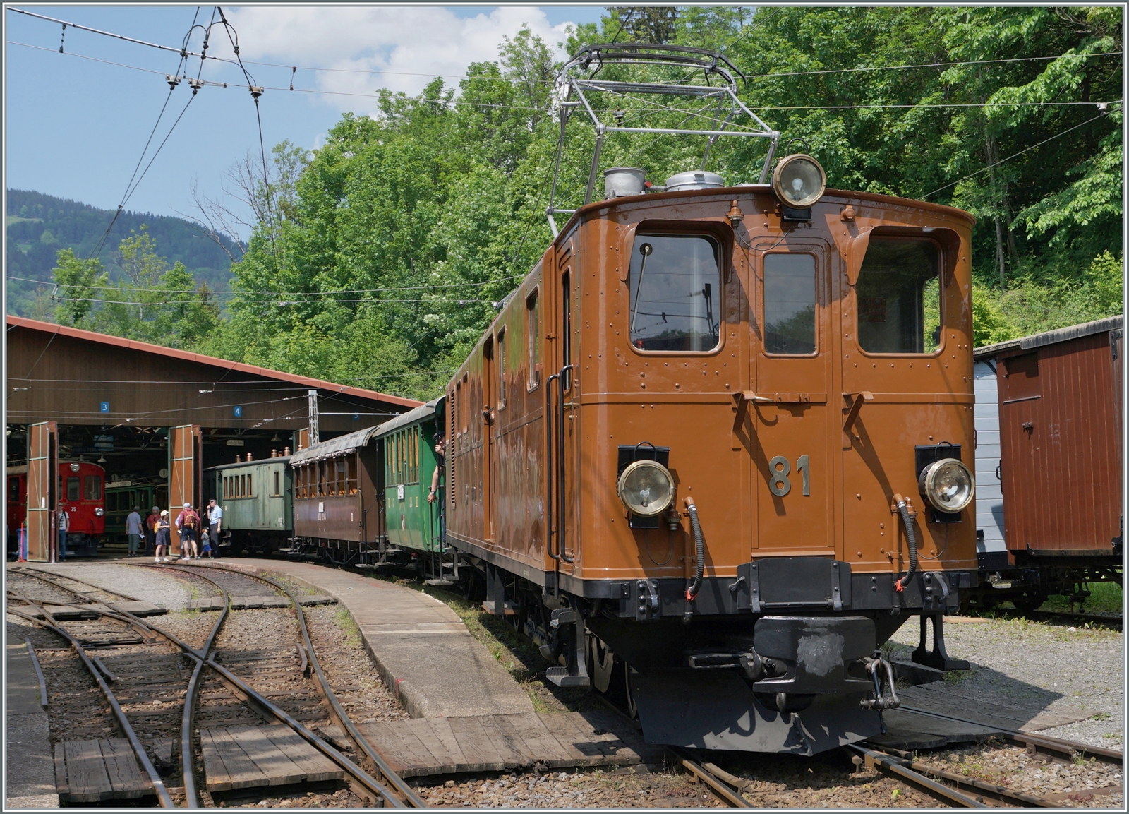 Die Bernina Bahn RhB Ge 4/4 81 der Blonay-Chamby Bahn ranigert in Chaulin einen langen Reisezug. Rechts im Hintergrund ist der RhB ABe 4/4 35 zu erkennen, der nun frisch gestrichen hoffentlich bald wieder im Einsatz zu erleben ist. 

28. Mai 2023