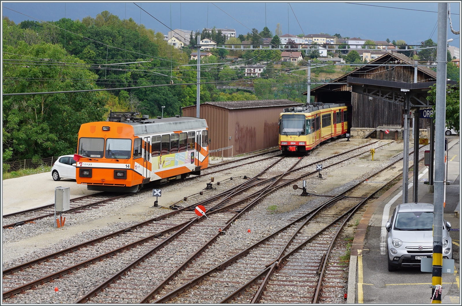 Ein Blick auf den Bahnhof von Orbe mit den beiden defekten TRAVYS Be 2/2 14 und Be 4/8 004. 

15. August 2022