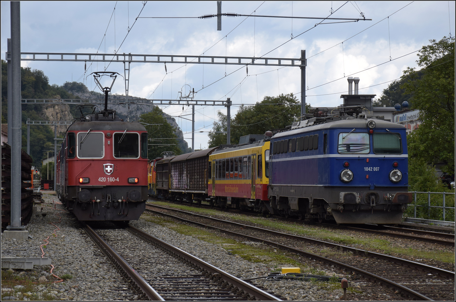 Grosses BoBo-Treffen in Balsthal - die Teilnehmerinnen:

Re 4/4 II 11160 von SBB Cargo ist inzwischen im rot/blauen Cargo-Gewand lackiert. Von vorne sieht man das allerdings nicht. Diese Lok entstammt der 2. Serie, die einige Verbesserungen erfahren hat. �usserlich ist dies schnell an den zwei Einholm-Stromabnehmern sichtbar. 

Ein Hydrant am Gleis und ein Zaun sorgen vor Ort f�r eine wunderbare Fotografenkanzel nahe am Gleis. Rechts ist die analoge Entwicklung der �BB als Zaungast der Veranstaltung im Bahnhof Klus. September 2024.