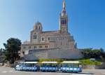  Ein Petit Train (ein Muson River 1894 vom italienischen Hersteller DOTTO TRAINS mit 3 Anhänger) steht zu Füssen der Marien-Wallfahrtskirche Notre-Dame de la Garde in Marseille am